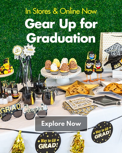 Assortment of graduation party supplies, including decorations, food, serveware, and more on a table