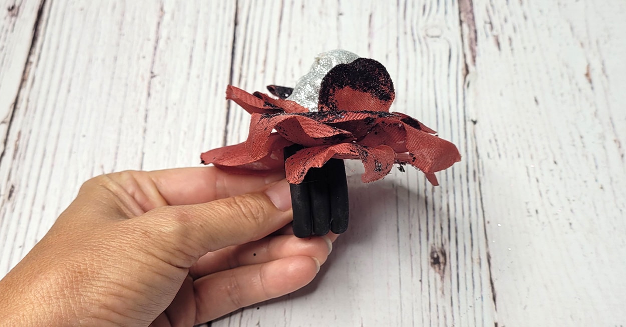 black wooden napkin ring with burgundy glittery flower and silver