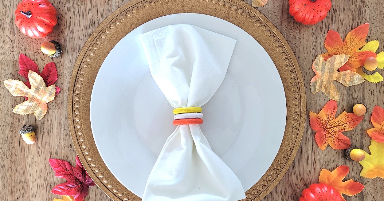 charger with white plate and white cloth napkin with wooden napkin ring