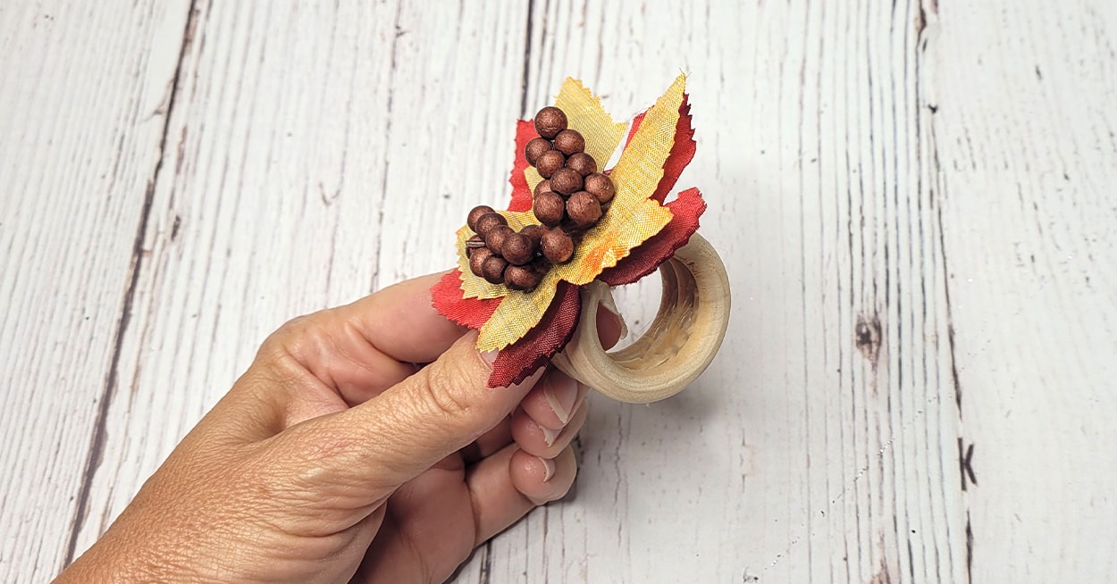 three wooden rings glued together with fabric leaves and berries glued