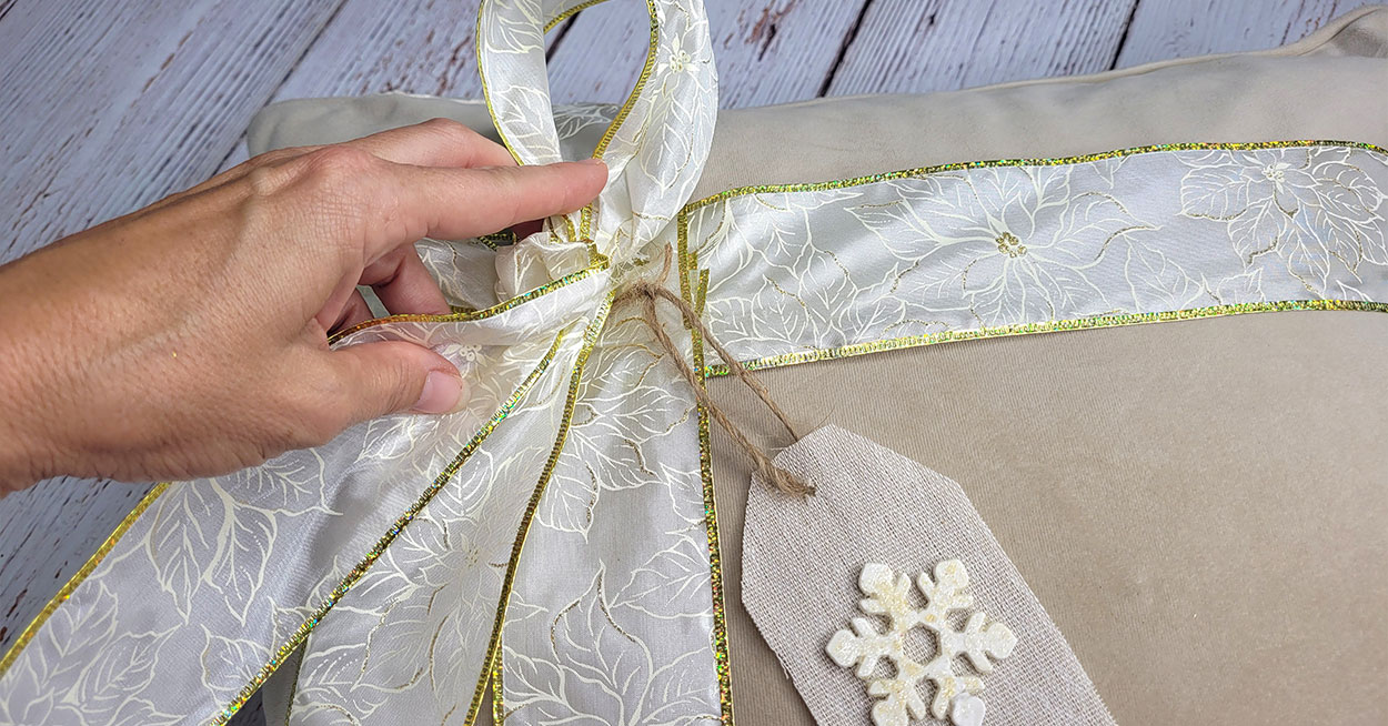 hand holding ribbon with a burlap tag on it