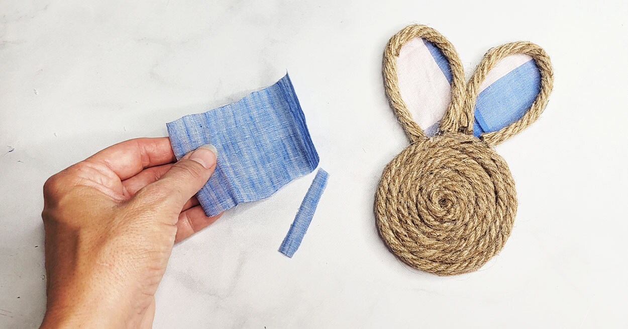 A nautical rope coaster shaped like a bunny, a hand holding a square of ...