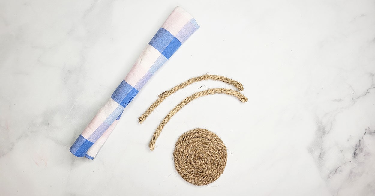 A roll of fabric, two pieces of nautical rope, and a round nautical ...