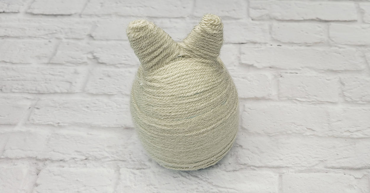 A bunny made of green yarn.