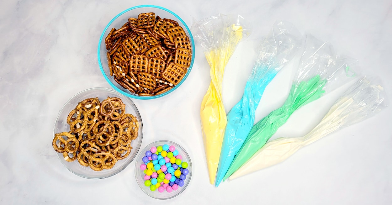 Bowls of pretzels and candy, and piping bags with icing in them