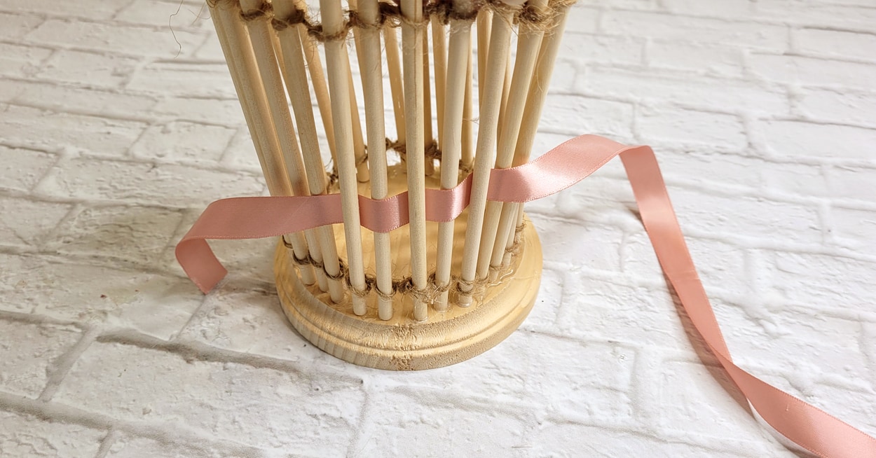 Ribbon being threading through dowel rods.