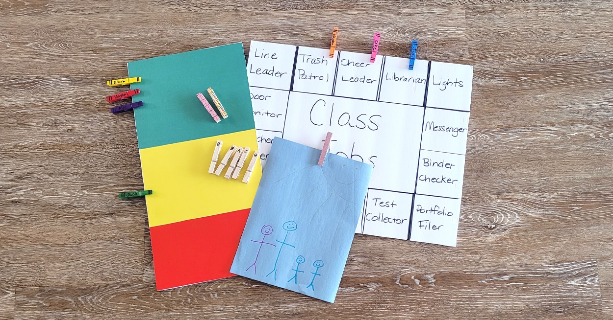 A chore chart, kids drawing, and different decorated clothespins.