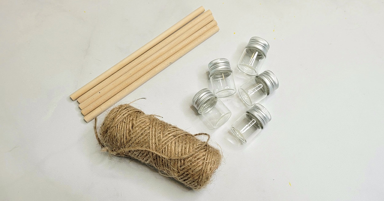 A roll of twine, small glass containers, and 5 dowel rods.