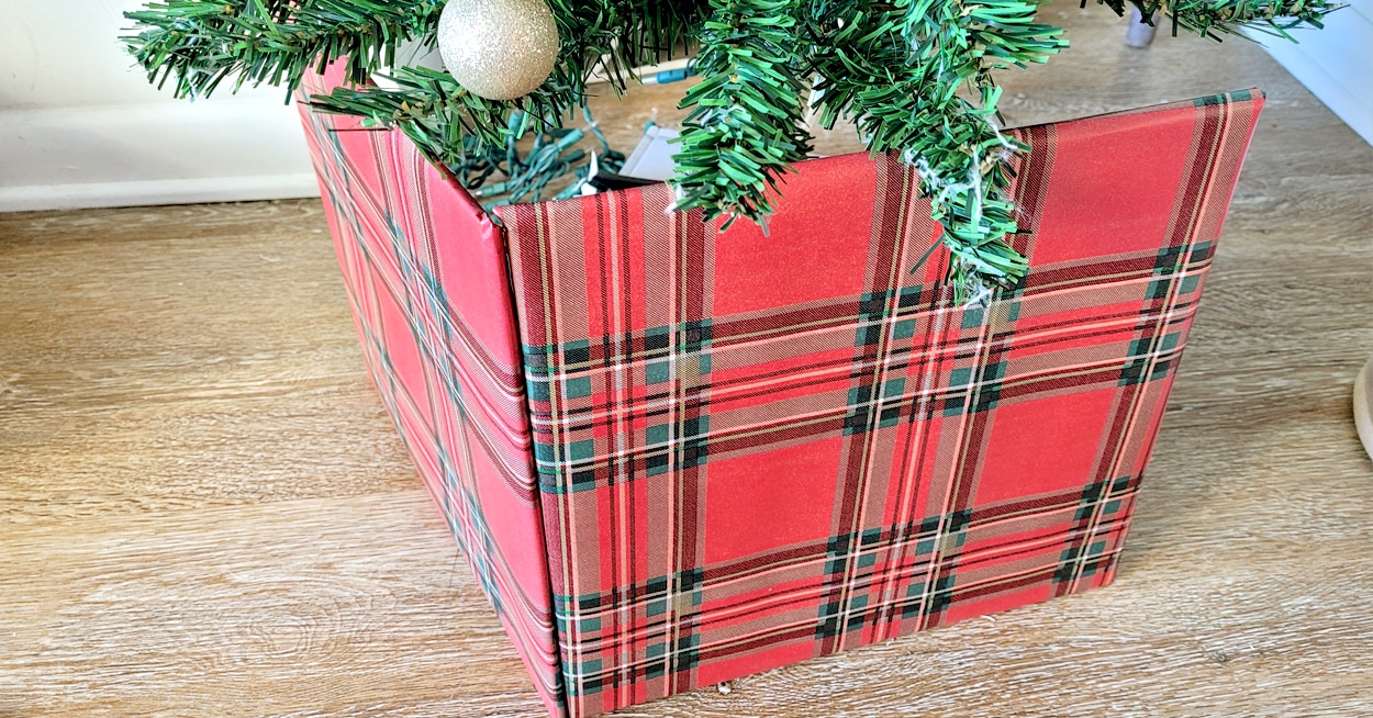 A Christmas tree with a plaid tree collar.