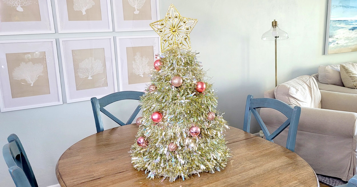 A small silver and gold tinsel tree with a gold star tree topper on top