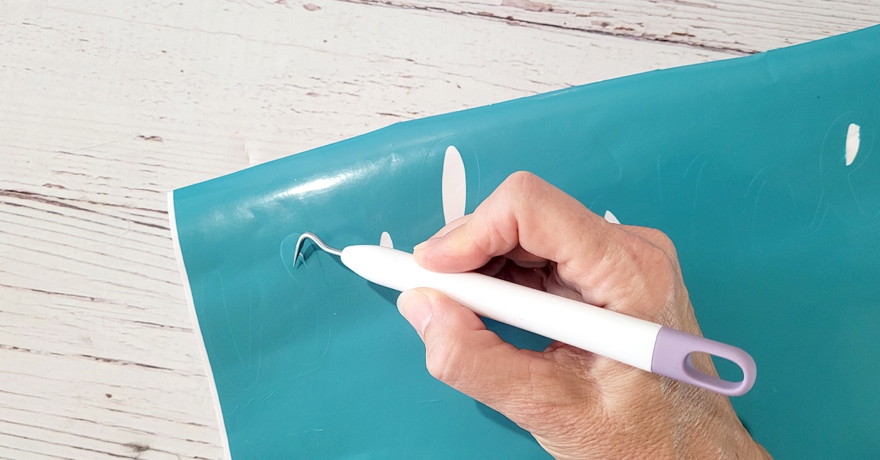 A clear mat with pink and green vinyl lettering on it.