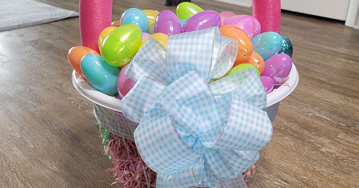 An oversized Easter basket with a blue and white bow on it.